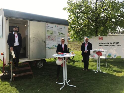 Drei DB-Mitarbeitende stehen vor dem Infowagen